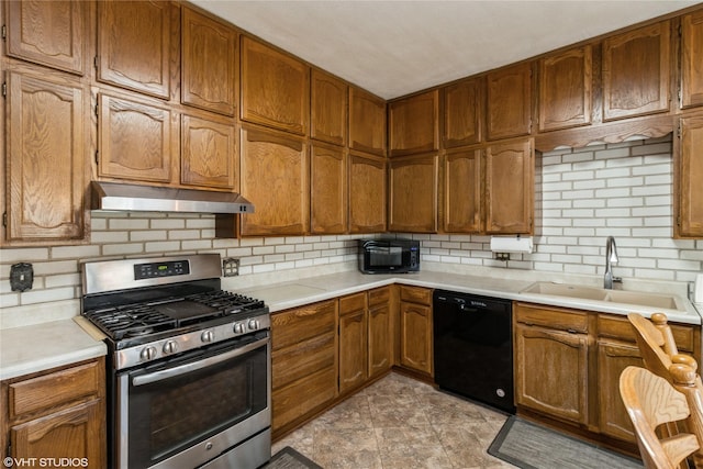 1723 6th St, Perry, IA 50220 - kitchen featuring black appliances, under cabinet range hood, a sink, backsplash, and light countertops