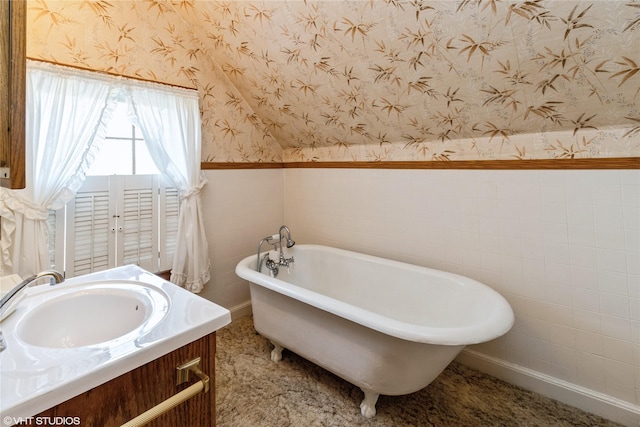 1723 6th St, Perry, IA 50220 - bathroom with wallpapered walls, a freestanding bath, wainscoting, and vanity