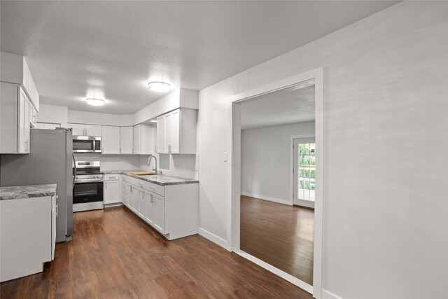 817 Roberts Ter, Marshalltown, IA 50158 - kitchen with stainless steel appliances, dark wood-type flooring, a sink, white cabinets, and baseboards