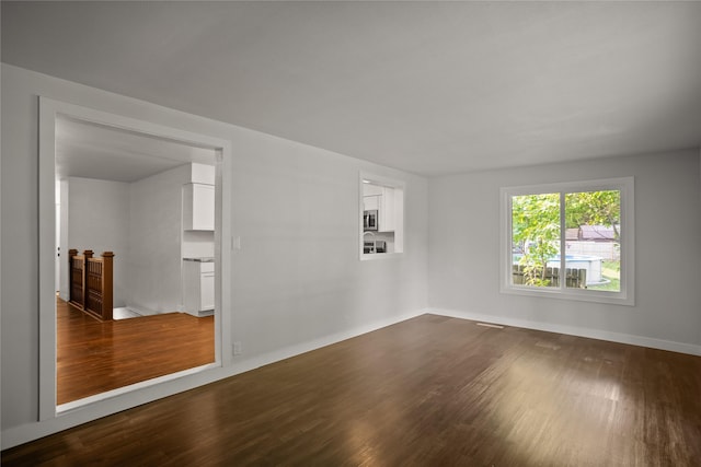 817 Roberts Ter, Marshalltown, IA 50158 - empty room featuring dark wood-type flooring and baseboards
