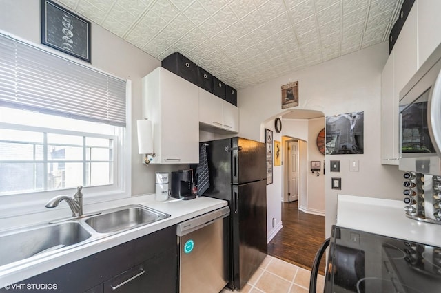 1073 66th St, Windsor Heights, IA 50324 - kitchen with stainless steel appliances, light countertops, light tile patterned flooring, an ornate ceiling, and white cabinets