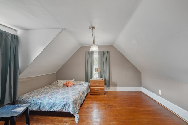 417 NE 2nd St, Panora, IA 50216 - bedroom featuring wood finished floors, vaulted ceiling, and baseboards