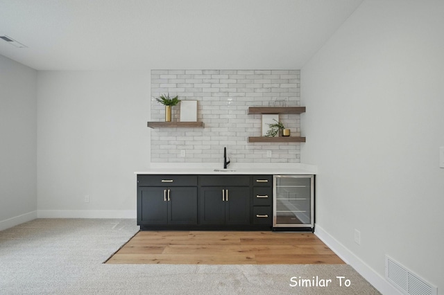 1801 Summit Cir NE, Bondurant, IA 50035 - indoor wet bar featuring beverage cooler, baseboards, and light colored carpet