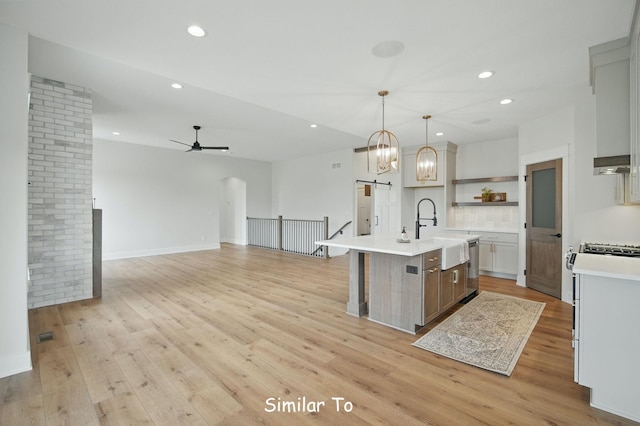 1801 Summit Cir NE, Bondurant, IA 50035 - kitchen featuring recessed lighting, light countertops, light wood-style floors, a barn door, and a ceiling fan