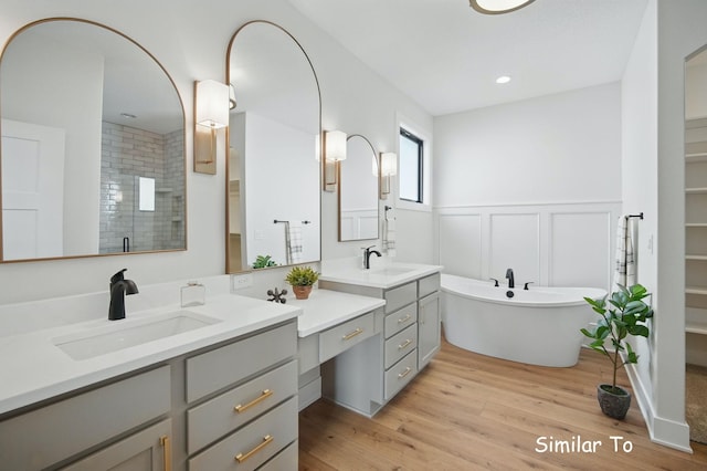 1801 Summit Cir NE, Bondurant, IA 50035 - full bathroom featuring vanity, wood finished floors, wainscoting, a soaking tub, and a tile shower