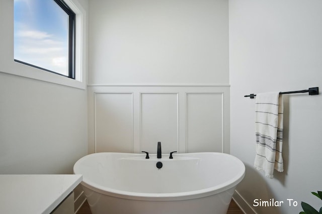 1801 Summit Cir NE, Bondurant, IA 50035 - bathroom featuring a decorative wall, a freestanding tub, wainscoting, and vanity
