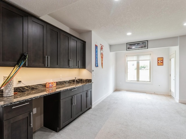 4485 NW 167th St, Clive, IA 50325 - kitchen with light colored carpet, dark stone countertops, baseboards, recessed lighting, and a textured ceiling
