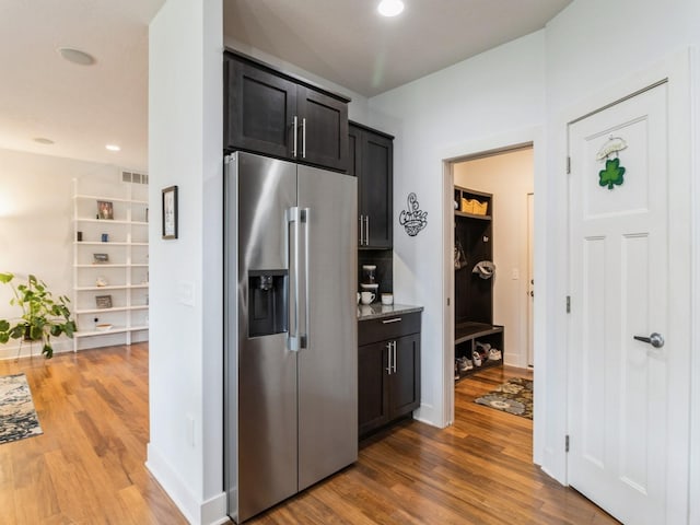 4485 NW 167th St, Clive, IA 50325 - kitchen with stainless steel fridge with ice dispenser, wood finished floors, dark cabinetry, light stone countertops, and recessed lighting