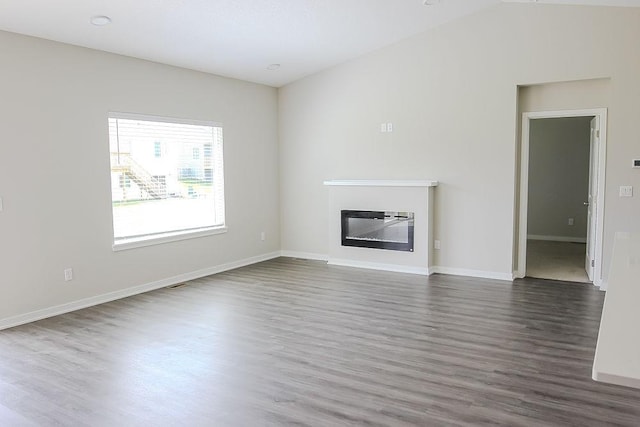 5515 167th St, Urbandale, IA 50323 - unfurnished living room featuring dark wood-type flooring, a glass covered fireplace, and baseboards