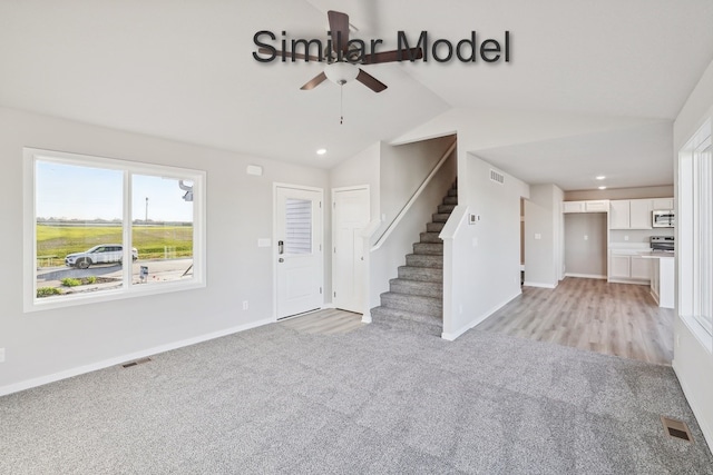 429 Napoli Ave, West Des Moines, IA 50266 - foyer featuring a ceiling fan, light carpet, vaulted ceiling, baseboards, and stairway