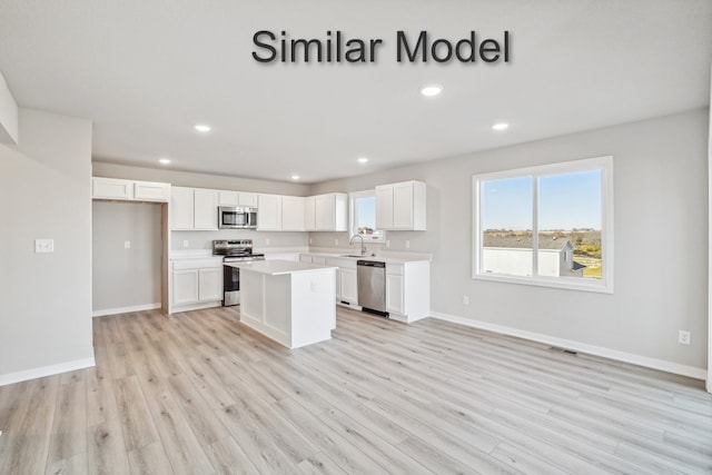 429 Napoli Ave, West Des Moines, IA 50266 - kitchen featuring appliances with stainless steel finishes, white cabinetry, light wood-type flooring, light countertops, and recessed lighting
