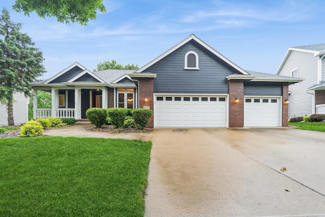 8148 Durham Cir, Johnston, IA 50131 - view of front of property featuring an attached garage, driveway, brick siding, a front lawn, and a porch