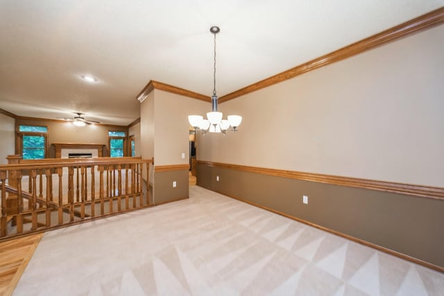 8148 Durham Cir, Johnston, IA 50131 - spare room featuring crown molding, a chandelier, a fireplace, and a ceiling fan