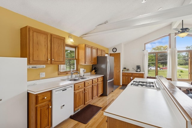 1801 Payton Ave, Des Moines, IA 50315 - kitchen with white appliances, a sink, light wood-style flooring, and brown cabinetry