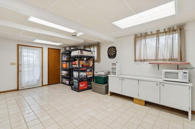 1801 Payton Ave, Des Moines, IA 50315 - kitchen with white microwave, light countertops, and white cabinetry