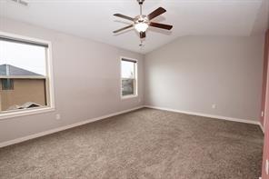 2430 SE Willowbrook Dr, Waukee, IA 50263 - empty room with vaulted ceiling, carpet floors, and baseboards