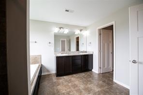 2430 SE Willowbrook Dr, Waukee, IA 50263 - full bathroom featuring double vanity, a bathtub, and baseboards