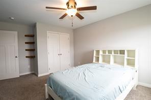 2430 SE Willowbrook Dr, Waukee, IA 50263 - carpeted bedroom with baseboards, a closet, and a ceiling fan