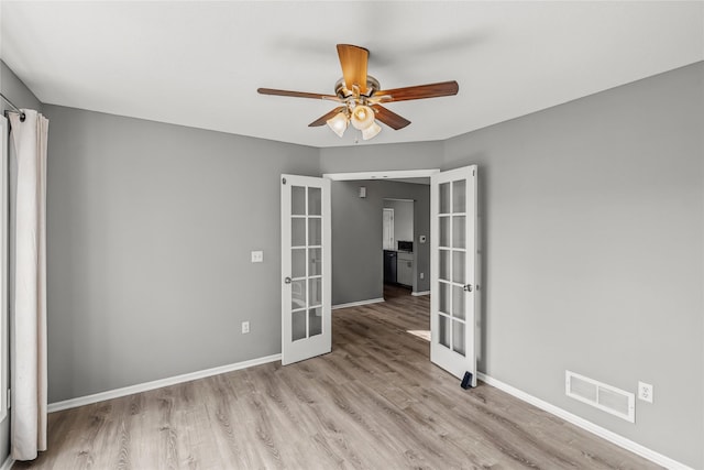904 SE Little Beaver Dr, Grimes, IA 50111 - empty room with french doors, light wood-style floors, ceiling fan, and baseboards