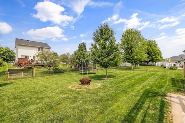 904 SE Little Beaver Dr, Grimes, IA 50111 - view of yard with a trampoline, a deck, and an outdoor fire pit