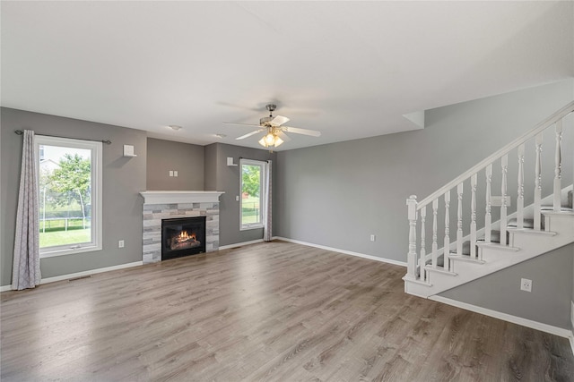 904 SE Little Beaver Dr, Grimes, IA 50111 - unfurnished living room featuring wood finished floors, baseboards, stairs, and a ceiling fan