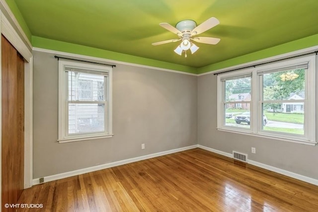 6445 Center St, Windsor Heights, IA 50324 - empty room featuring baseboards, plenty of natural light, and wood finished floors