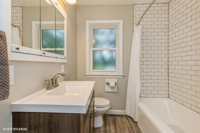 6445 Center St, Windsor Heights, IA 50324 - bathroom with toilet, vanity, wood finished floors, shower / bathtub combination with curtain, and baseboards