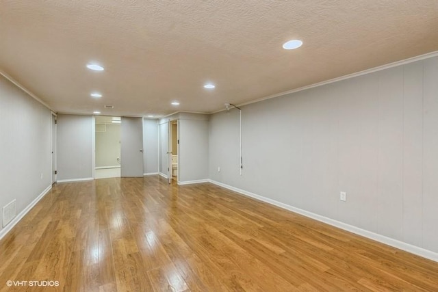 6445 Center St, Windsor Heights, IA 50324 - finished basement with light wood-style floors, recessed lighting, crown molding, baseboards, and a textured ceiling
