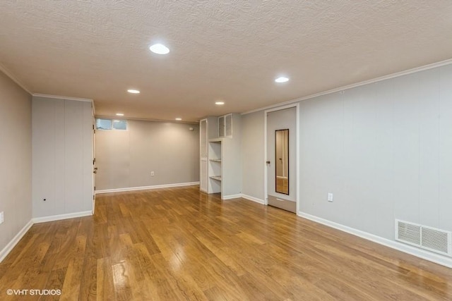 6445 Center St, Windsor Heights, IA 50324 - finished below grade area with light wood-type flooring, a textured ceiling, baseboards, recessed lighting, and crown molding