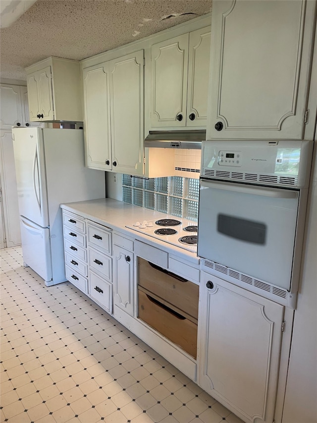 1620 Broad St, Grinnell, IA 50112 - kitchen featuring white appliances, under cabinet range hood, light countertops, light floors, and a warming drawer
