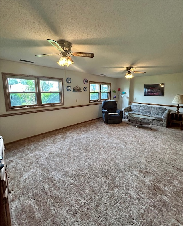 324 E 14th St N, Newton, IA 50208 - carpeted living room featuring a ceiling fan, a textured ceiling, and baseboards