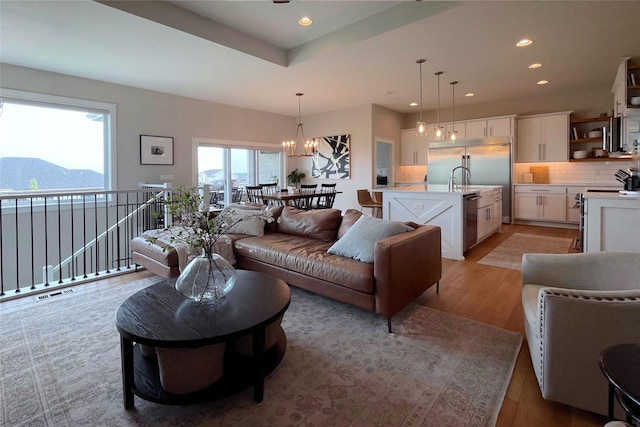 1000 NE 23rd St, Grimes, IA 50111 - living room featuring light wood-type flooring, recessed lighting, and a chandelier