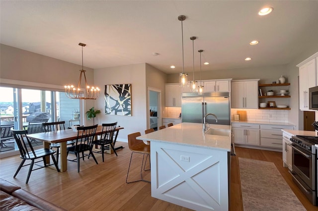 1000 NE 23rd St, Grimes, IA 50111 - kitchen with high quality appliances, a sink, recessed lighting, backsplash, and white cabinets