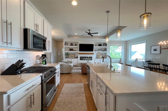 1000 NE 23rd St, Grimes, IA 50111 - kitchen with appliances with stainless steel finishes, ceiling fan, light wood-style flooring, white cabinets, and recessed lighting
