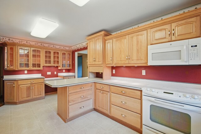 4500 100th St, Urbandale, IA 50322 - kitchen with white appliances, glass insert cabinets, light countertops, a peninsula, and light floors