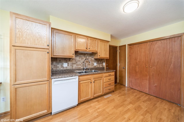 312 NE Harvey St, Grimes, IA 50111 - kitchen featuring white dishwasher, a sink, dark countertops, light wood finished floors, and tasteful backsplash