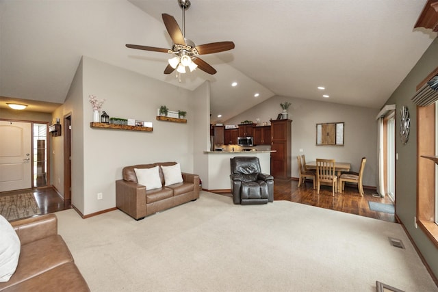 1324 Joshua Cir SE, Bondurant, IA 50035 - living room with vaulted ceiling, dark colored carpet, ceiling fan, baseboards, and recessed lighting