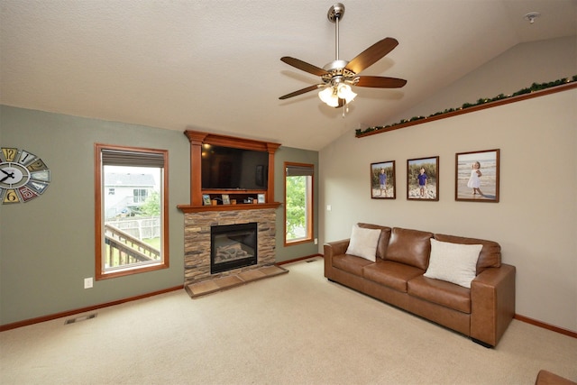 1324 Joshua Cir SE, Bondurant, IA 50035 - carpeted living room with vaulted ceiling, a ceiling fan, baseboards, and a stone fireplace