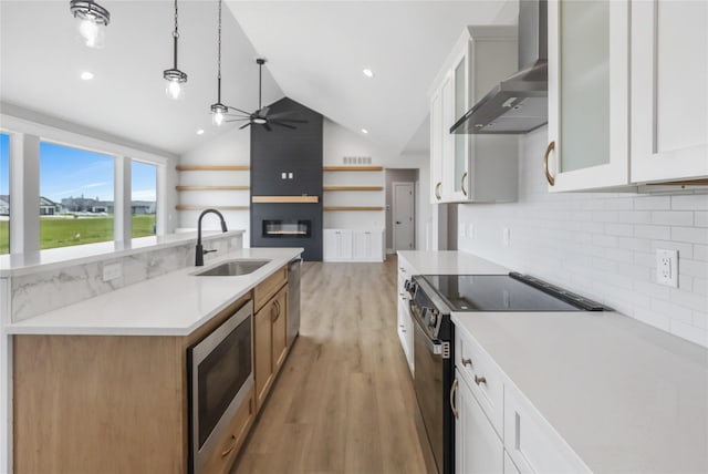 1201 Lakeview Cir NW, Bondurant, IA 50035 - kitchen with electric range oven, wall chimney exhaust hood, stainless steel microwave, a sink, and a ceiling fan