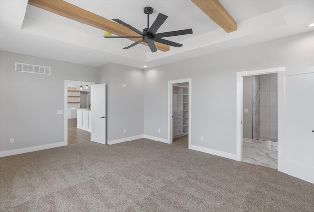 1201 Lakeview Cir NW, Bondurant, IA 50035 - unfurnished bedroom featuring a spacious closet, baseboards, carpet, ensuite bathroom, and beam ceiling