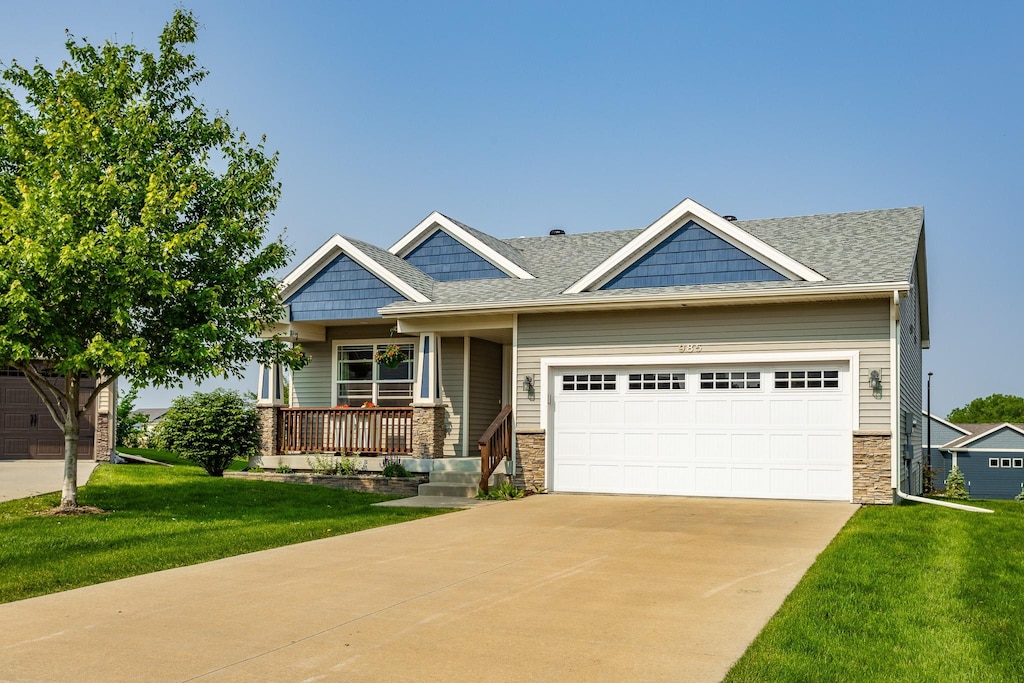 985 S 90th St, West Des Moines, IA 50266 - craftsman-style home with stone siding, covered porch, and a front yard
