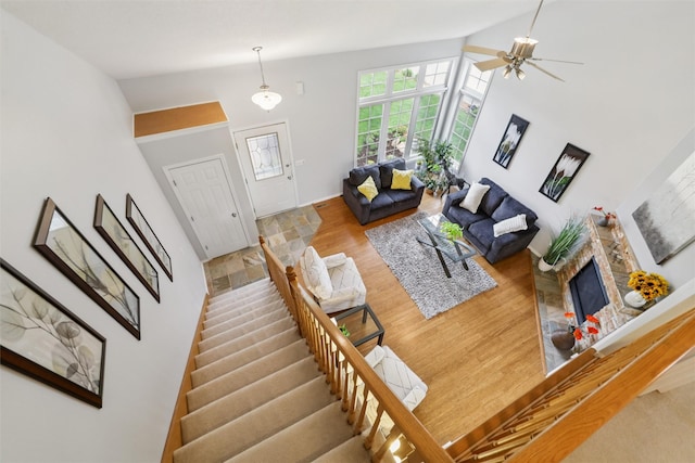 1822 30th Ave SW, Altoona, IA 50009 - living room with light wood-style flooring, high vaulted ceiling, stairway, a stone fireplace, and a ceiling fan