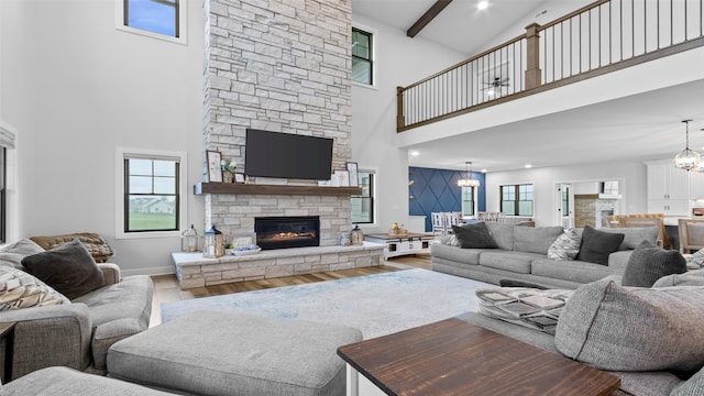 100 Coventry Ct, Clear Lake, IA 50428 - living area featuring a towering ceiling, wood finished floors, a fireplace, healthy amount of natural light, and a chandelier