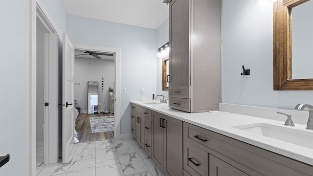 100 Coventry Ct, Clear Lake, IA 50428 - bathroom with double vanity, marble look tile flooring, ceiling fan, and baseboards