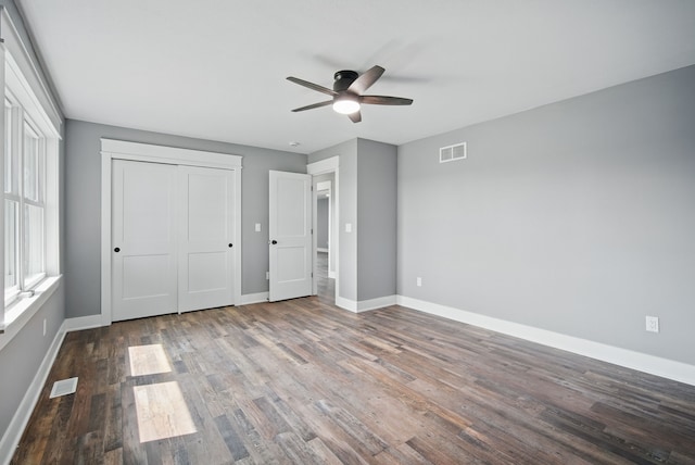 1026 44th Hwy, Guthrie Center, IA 50115 - unfurnished bedroom featuring baseboards, wood finished floors, a closet, and ceiling fan