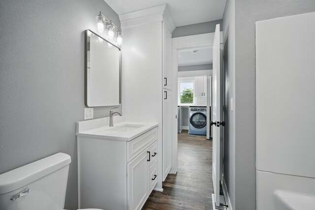 1026 44th Hwy, Guthrie Center, IA 50115 - half bathroom featuring washer / dryer, toilet, vanity, and wood finished floors