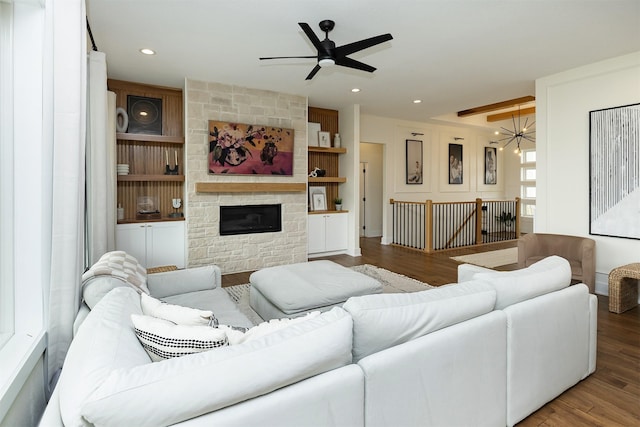 1030 Harrington Way, Waukee, IA 50263 - living area featuring wood finished floors, a ceiling fan, a stone fireplace, recessed lighting, and built in shelves