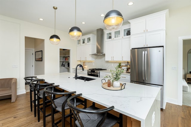 1030 Harrington Way, Waukee, IA 50263 - kitchen featuring appliances with stainless steel finishes, wall chimney range hood, white cabinetry, a large island, and hardwood / wood-style floors