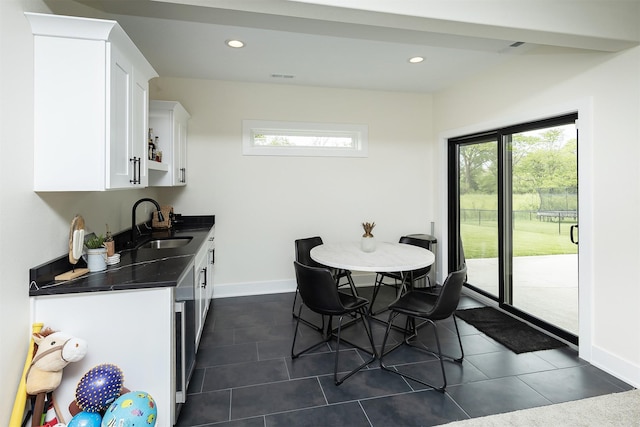 1030 Harrington Way, Waukee, IA 50263 - kitchen featuring dark countertops, white cabinets, healthy amount of natural light, dark tile patterned floors, and recessed lighting