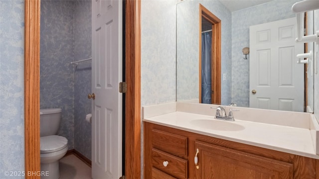 1105 E Henderson Pl, Indianola, IA 50125 - bathroom with wallpapered walls, toilet, and vanity
